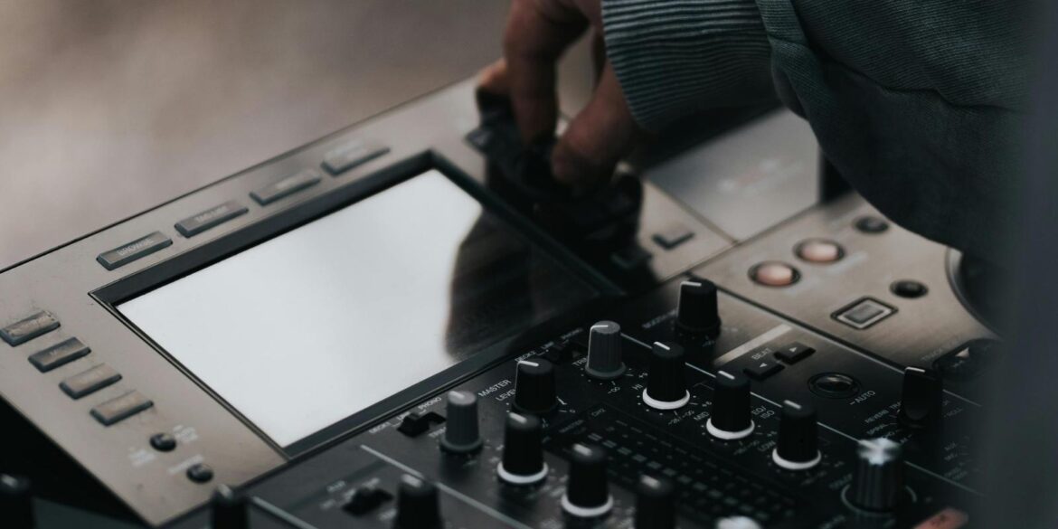 Vingers die aan knoppen zitten van een DJ set