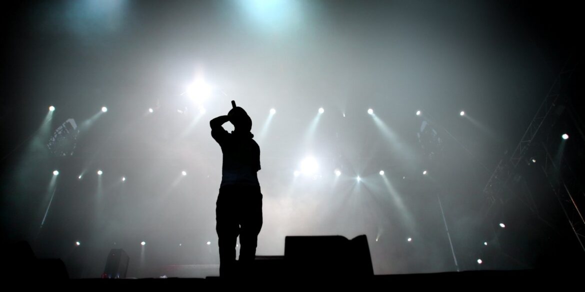 Een man bij een hiphop concert op het podium