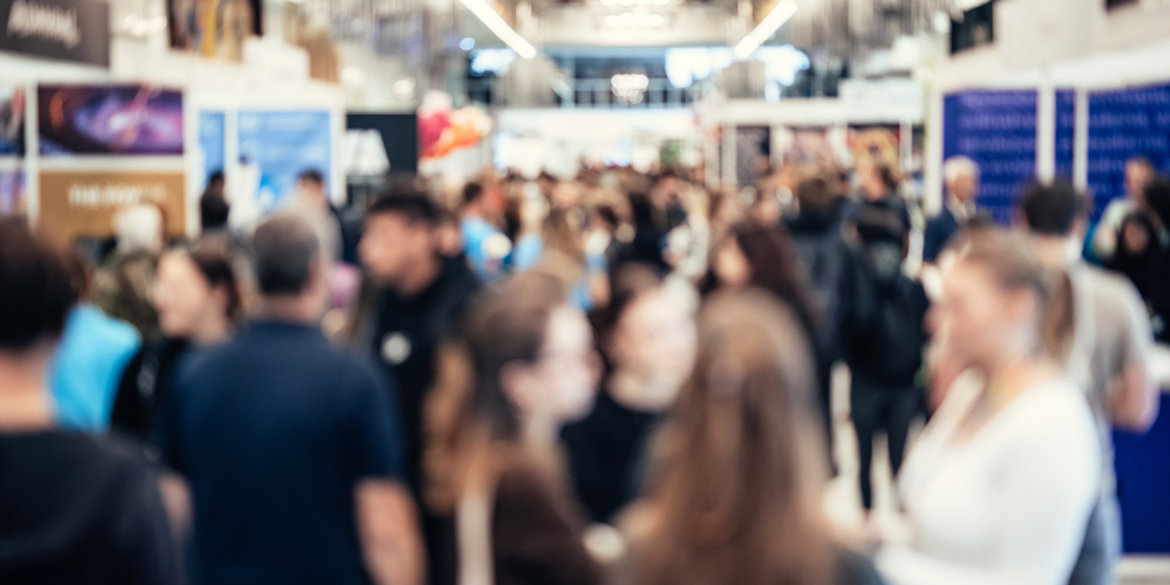 Een foto van mensen bij een beurs.